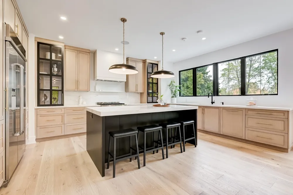 A beautifully remodeled modern kitchen in Kansas City featuring new hardwood flooring, custom cabinet installation, and fresh interior paint by Superior Paint & Remodeling LLC.